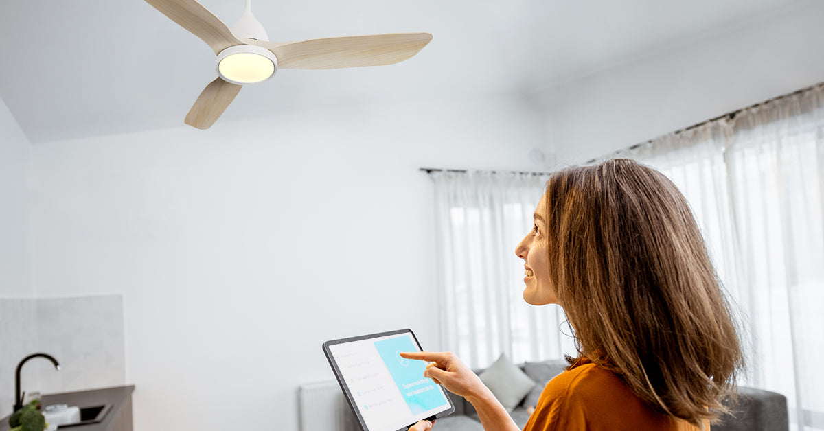 52 inch Koa smart ceiling fan with LED light is controlled by an ipad which held by a lady. 