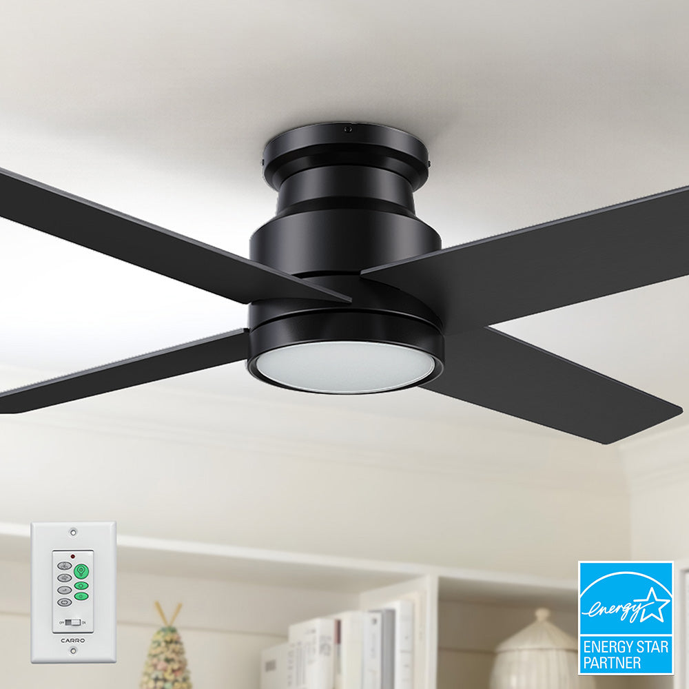A black SmaFan Olinda 52-inch flush mount ceiling fan with LED light and four blades  , shown installed on a white ceiling above a bookshelf, with a white wall control switch also visible in the bottom left corner. 
