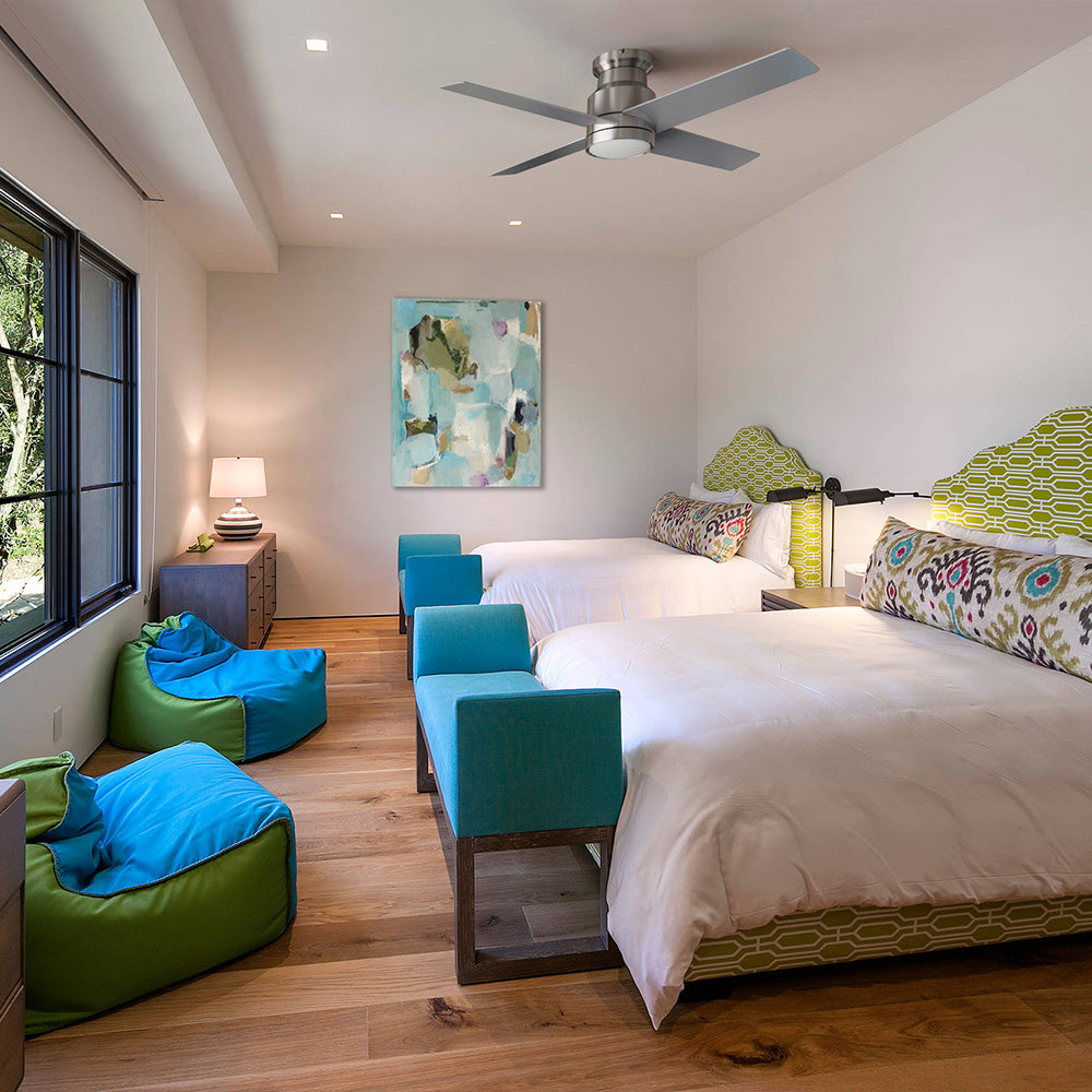 Modern bohemian bedroom with two queen beds, featuring vibrant turquoise and lime green headboards and matching bean bag chairs under a low-profile Brushed Nickel ceiling fan. 