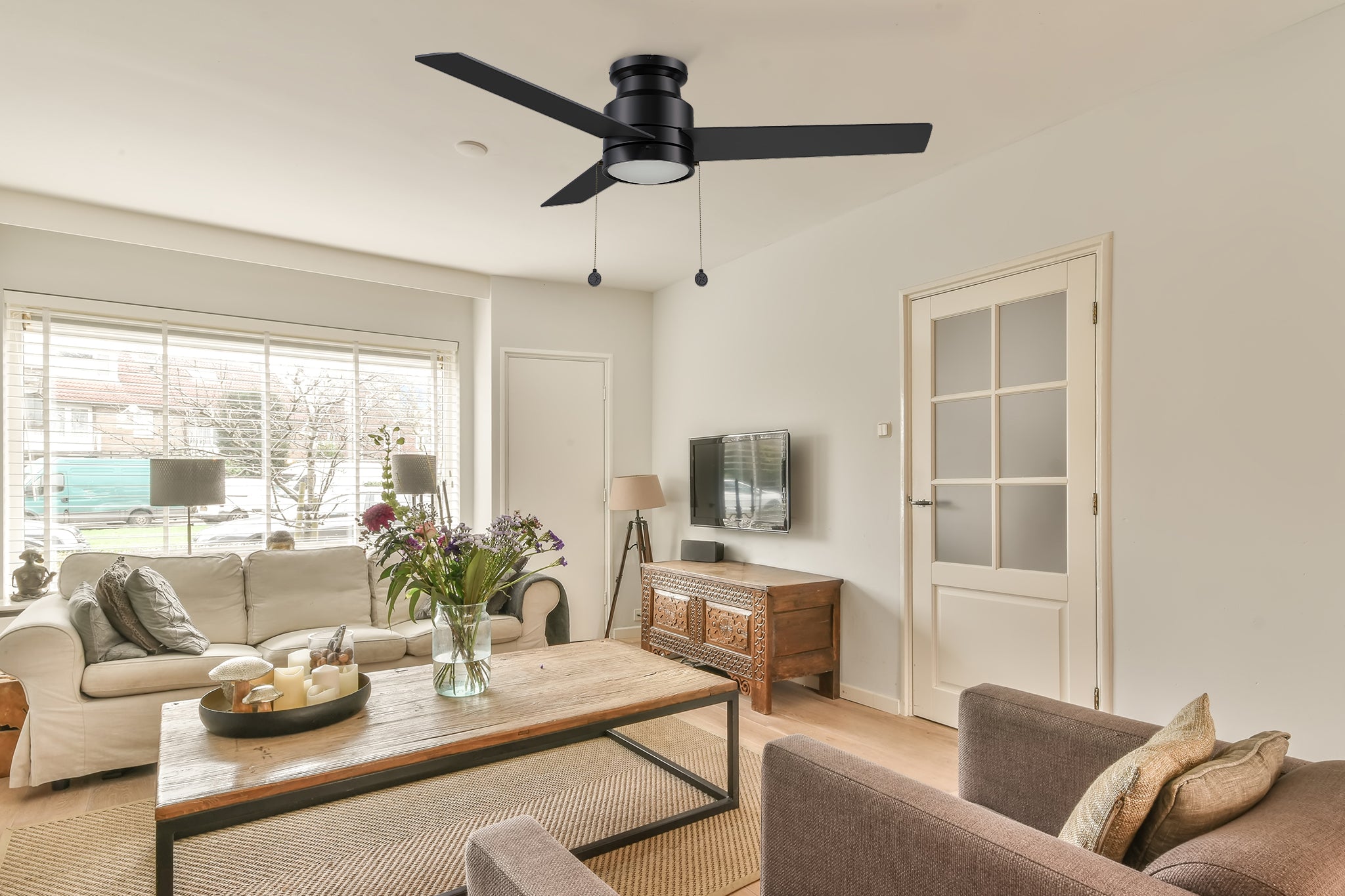 52 inch black flush mounting ceiling fan with LED light and pull chain, matching to white and brown sofa, wooden coffee table, white door, which makes the whole bedroom color collocation is very reasonable, and has a modern sense.