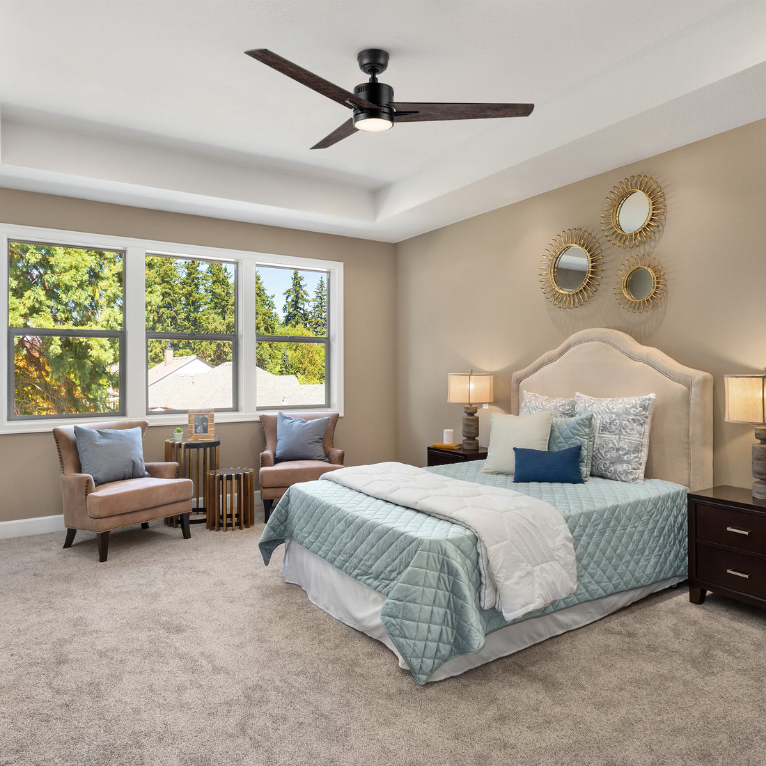 A modern bedroom featuring a Skobeloff 52-inch smart ceiling fan with LED light, mounted on a white ceiling for efficient airflow and cooling. The ceiling fan has dark blades and complements the room&