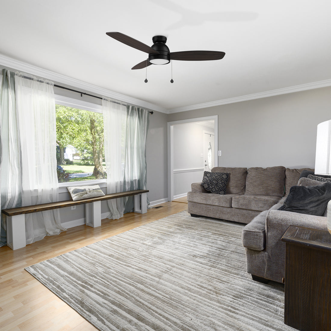 Carro Troyes 52 inch pull chain ceiling fan, dark wood design, and an integrated 4000K LED cool light, low profile, installed in a livingrom. 