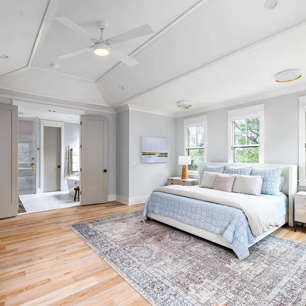 White Smafan Admiral 52-inch ceiling fan with light installed on a tray ceiling in a French Country bedroom with light blue bedding. 