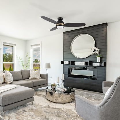 Modern living room featuring the Smafan Biscay 48-inch smart ceiling fan in black with integrated light. The space includes a grey sectional sofa, round mirrored coffee table, and a black accent wall with a circular mirror and electric fireplace. 