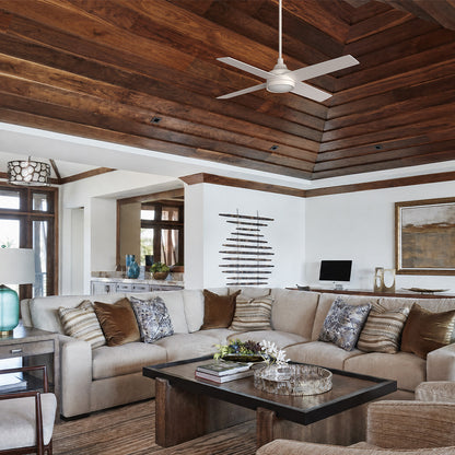 Smafan Bryant 52 inch white ceiling fan with light installed on a high vaulted wood ceiling in a mountain modern resort living room with a large sectional sofa and rustic wood coffee table. 