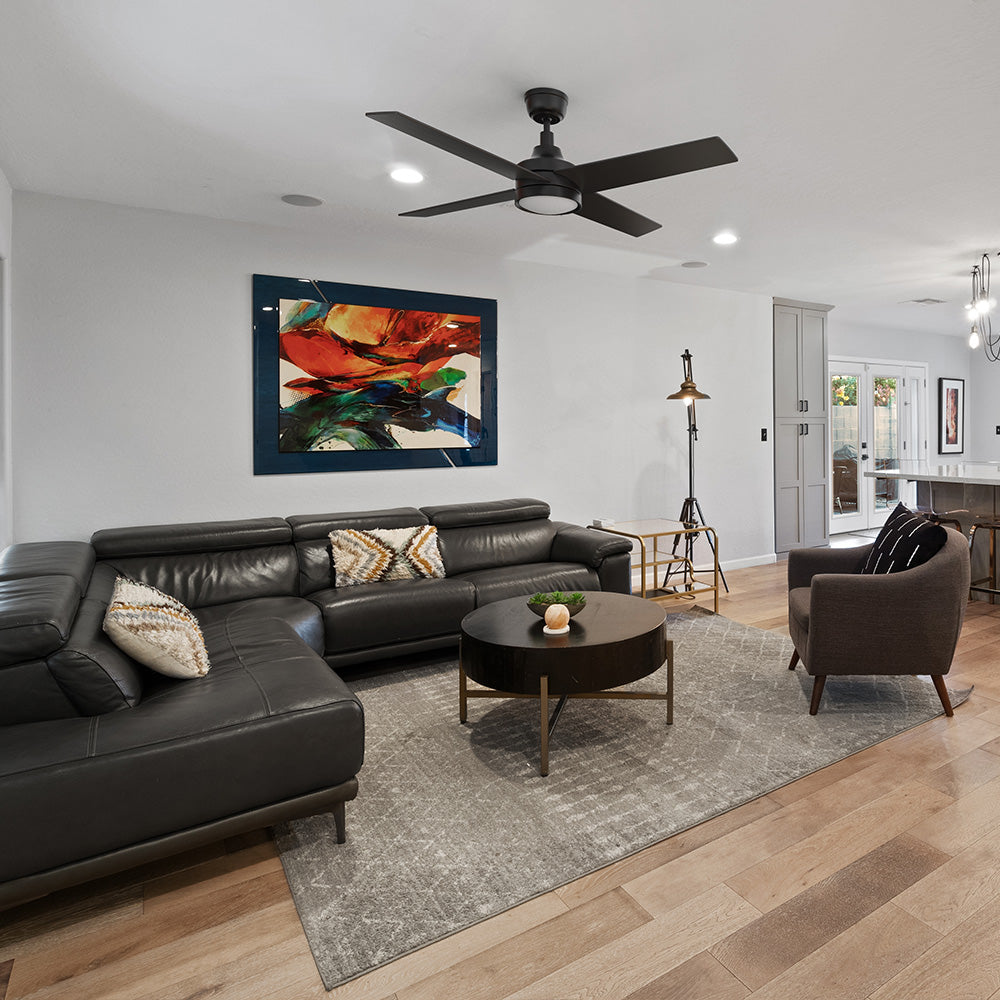 Smafan Bryant 52 inch black ceiling fan with light installed in a modern living room featuring a black leather sectional sofa, round wood coffee table, and vibrant wall art. 