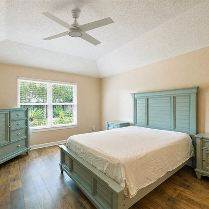 Smafan Bryant 52 inch white ceiling fan with light installed on a vaulted ceiling in a coastal cottage bedroom featuring light sage green wooden furniture and beige walls. 