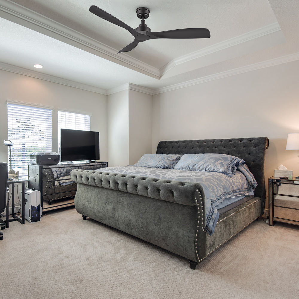 Smafan Kilk 52-inch smart ceiling fan in black, without light, installed in a bedroom with a gray upholstered bed, white bedding, nightstands with lamps, a carpeted floor, and a window with blinds. 