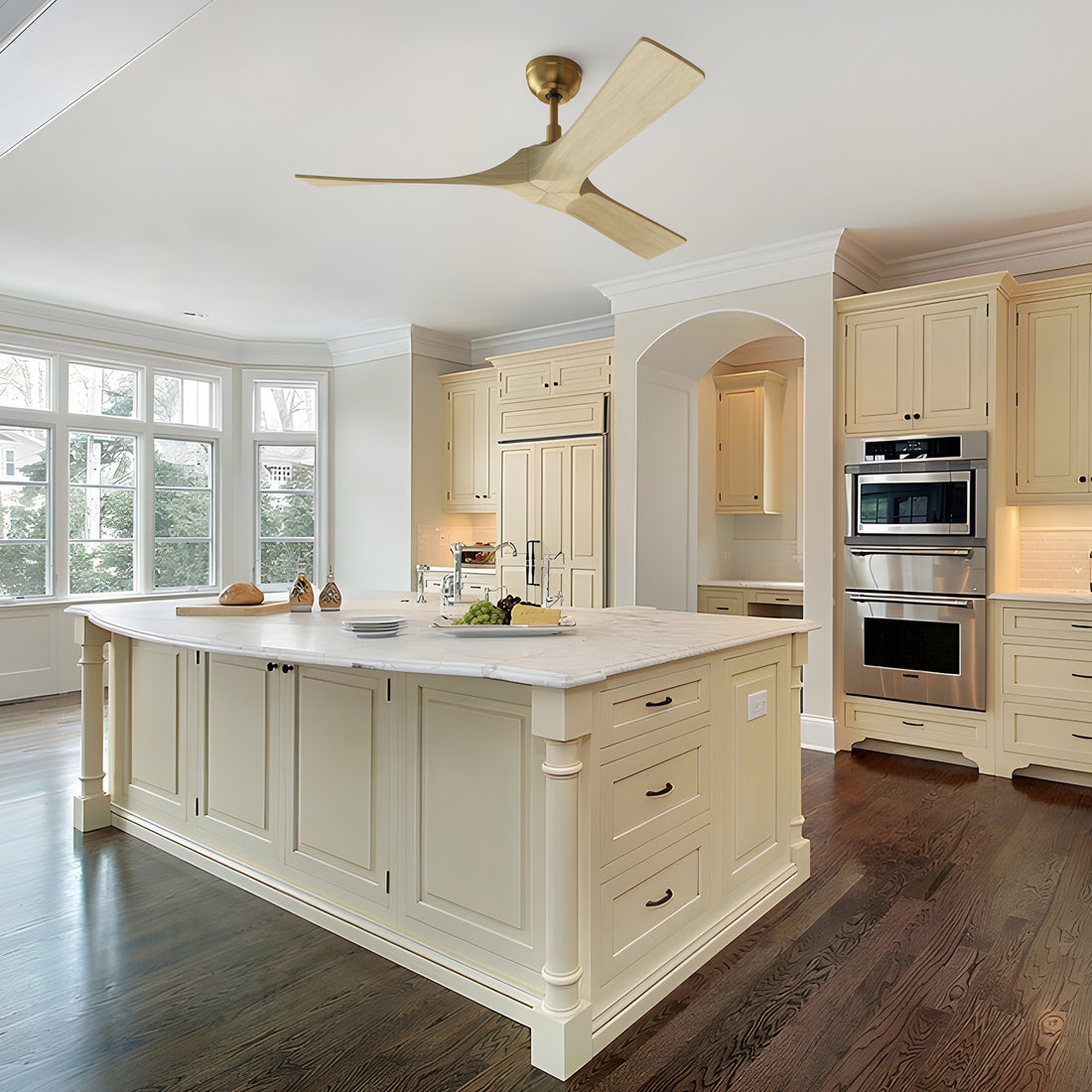 Spacious open-concept kitchen with cream cabinetry and a marble island, highlighted by a 52-inch Smafan Matthews ceiling fan with light wood blades and a brass downrod, offering elegant airflow without an LED light fixture. 