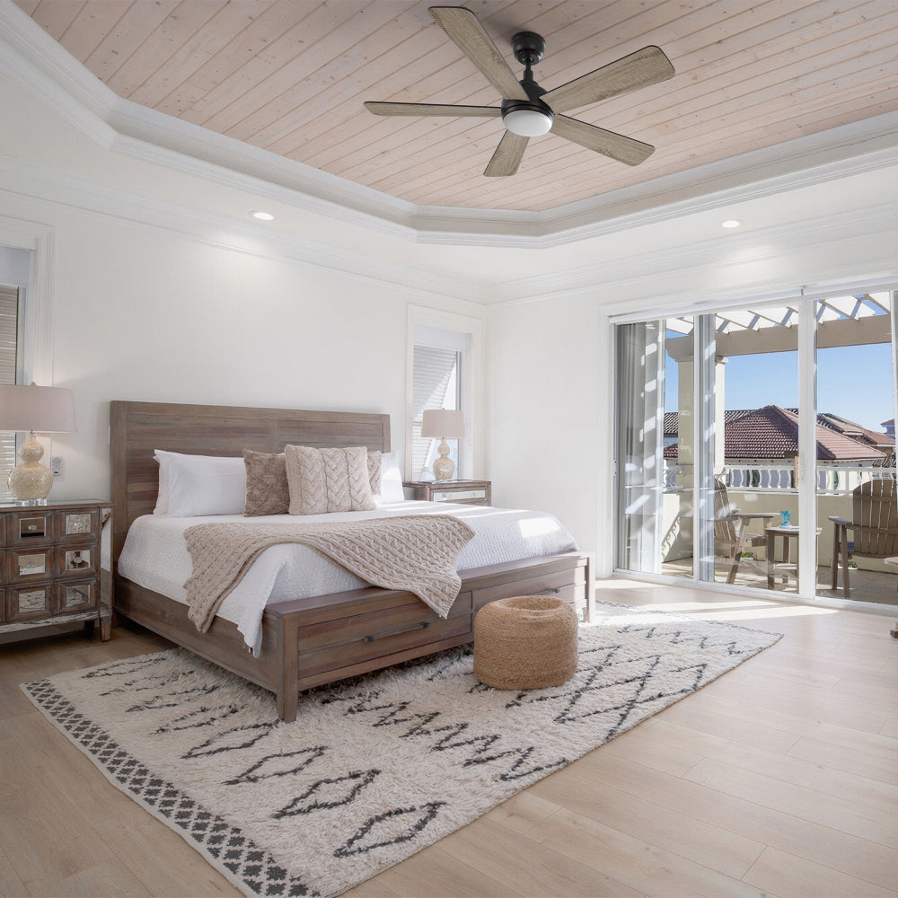 Cozy rustic bedroom with Smafan Toplam 52" wood ceiling fan with light on plank ceiling, wood bed frame, and glass doors to balcony. Shows what size ceiling fan for bedroom (52" ideal for this room). 
