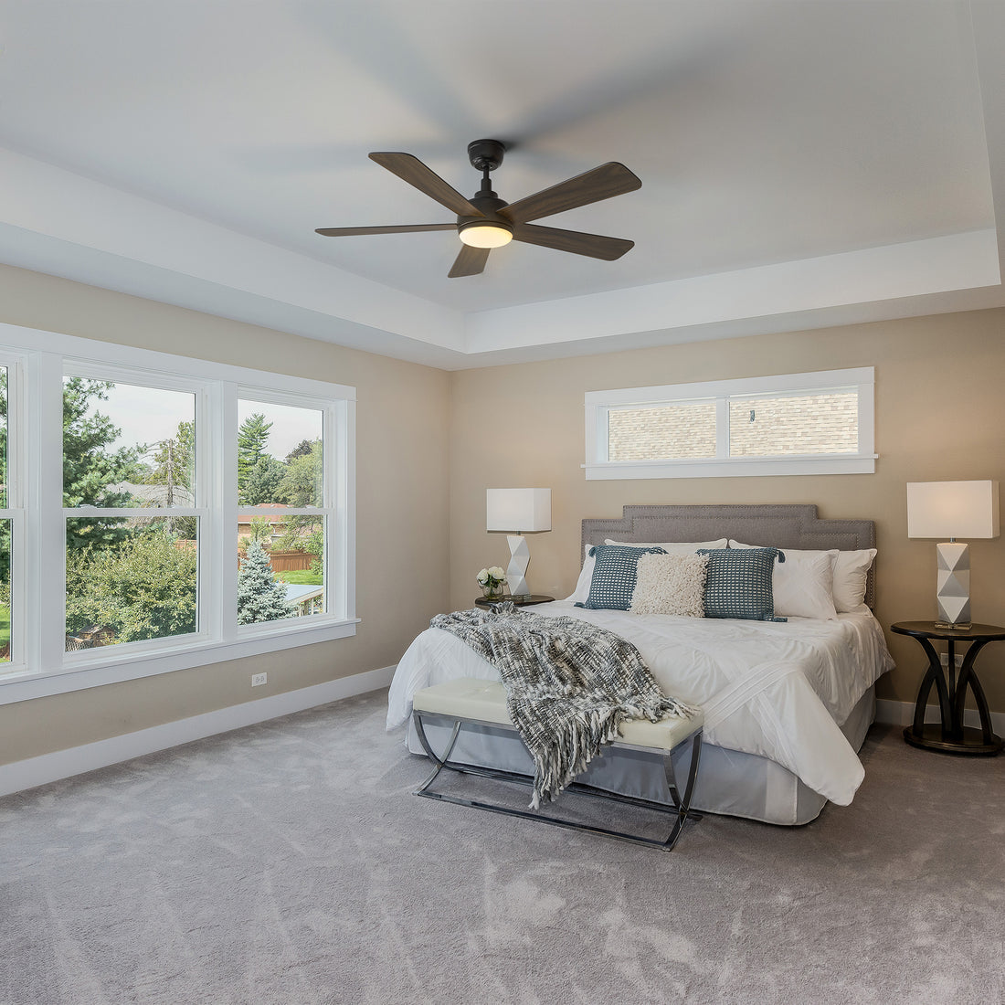 Smafan Toplam 52 inch wood ceiling fan with bright light in a traditional bedroom featuring a large bed with white linens, a white bench, matching nightstands with lamps, and large windows overlooking greenery. 