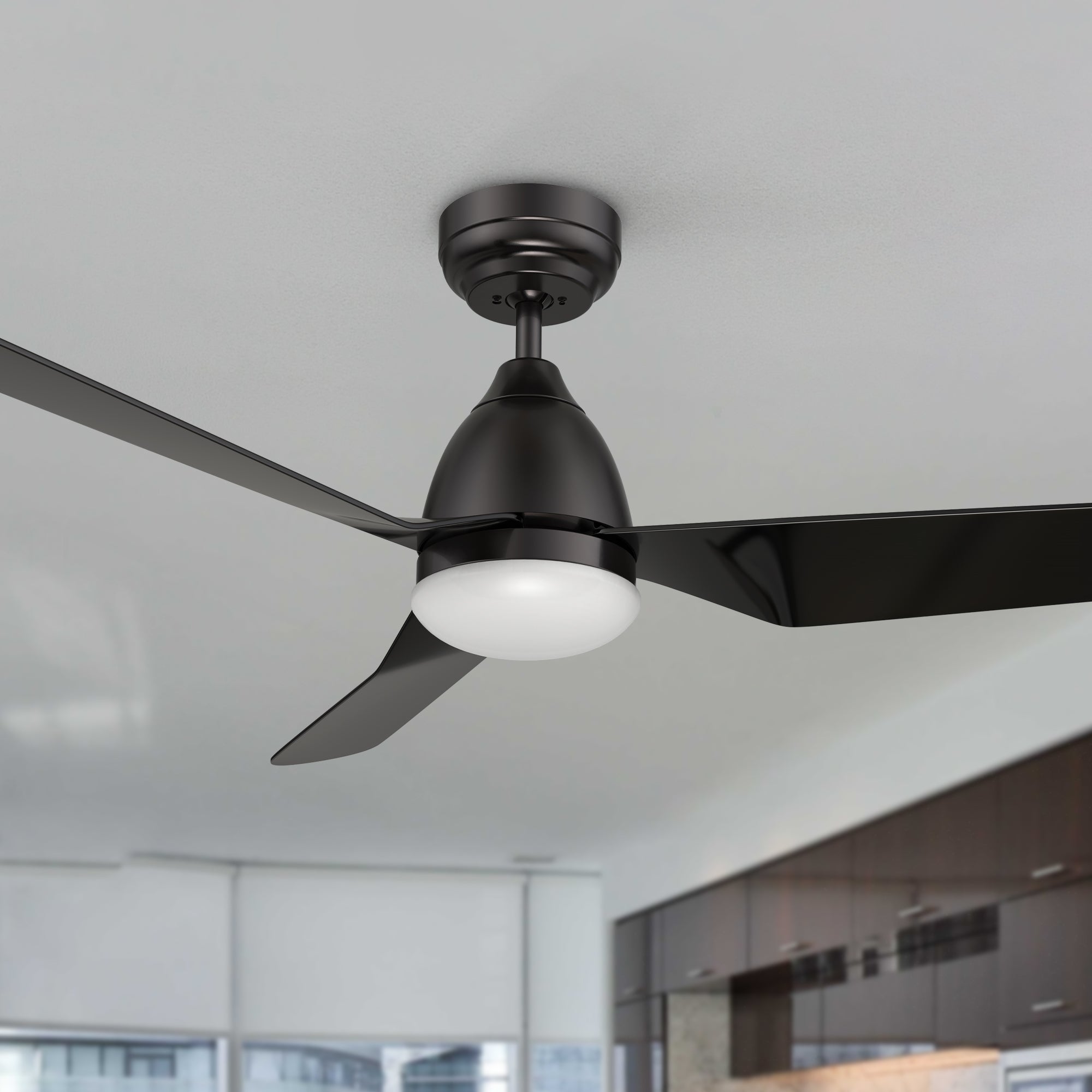 A modern Triton 52-inch ceiling fan with LED light and smart features installed in a bright, minimalist kitchen-living area. 