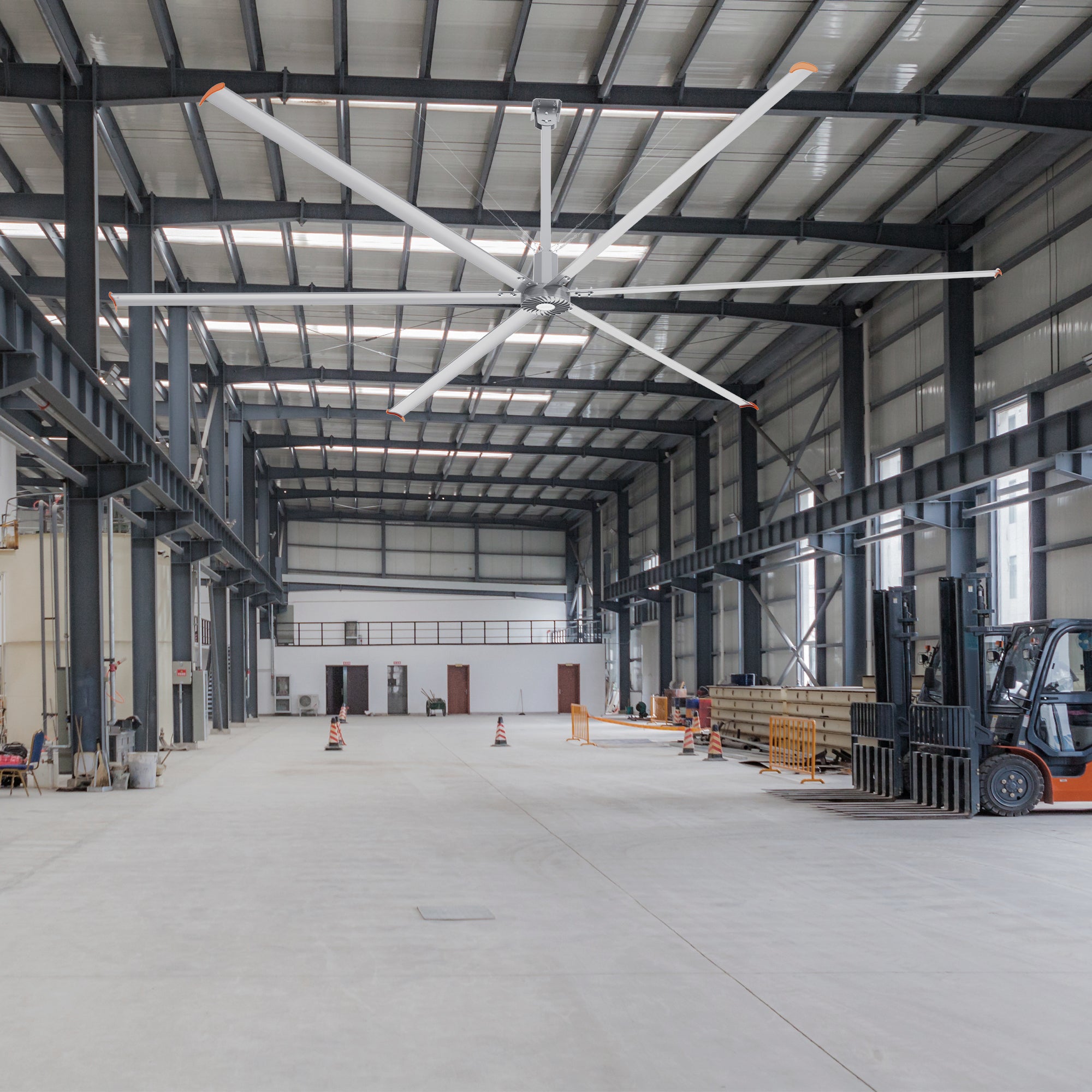 24ft Industrial fan operating in a factory setting with various equipment. 