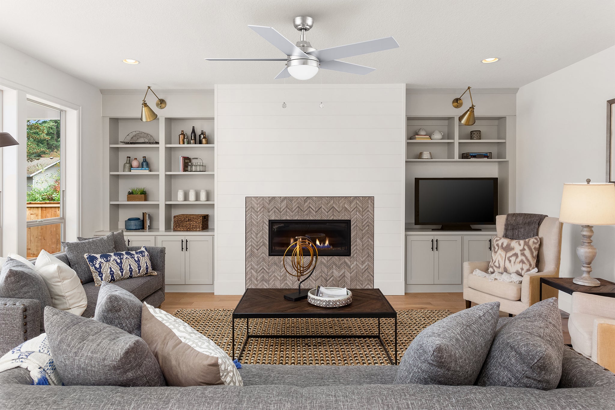 Five blades silver ceiling fan with light and pull chain function in modern living room.