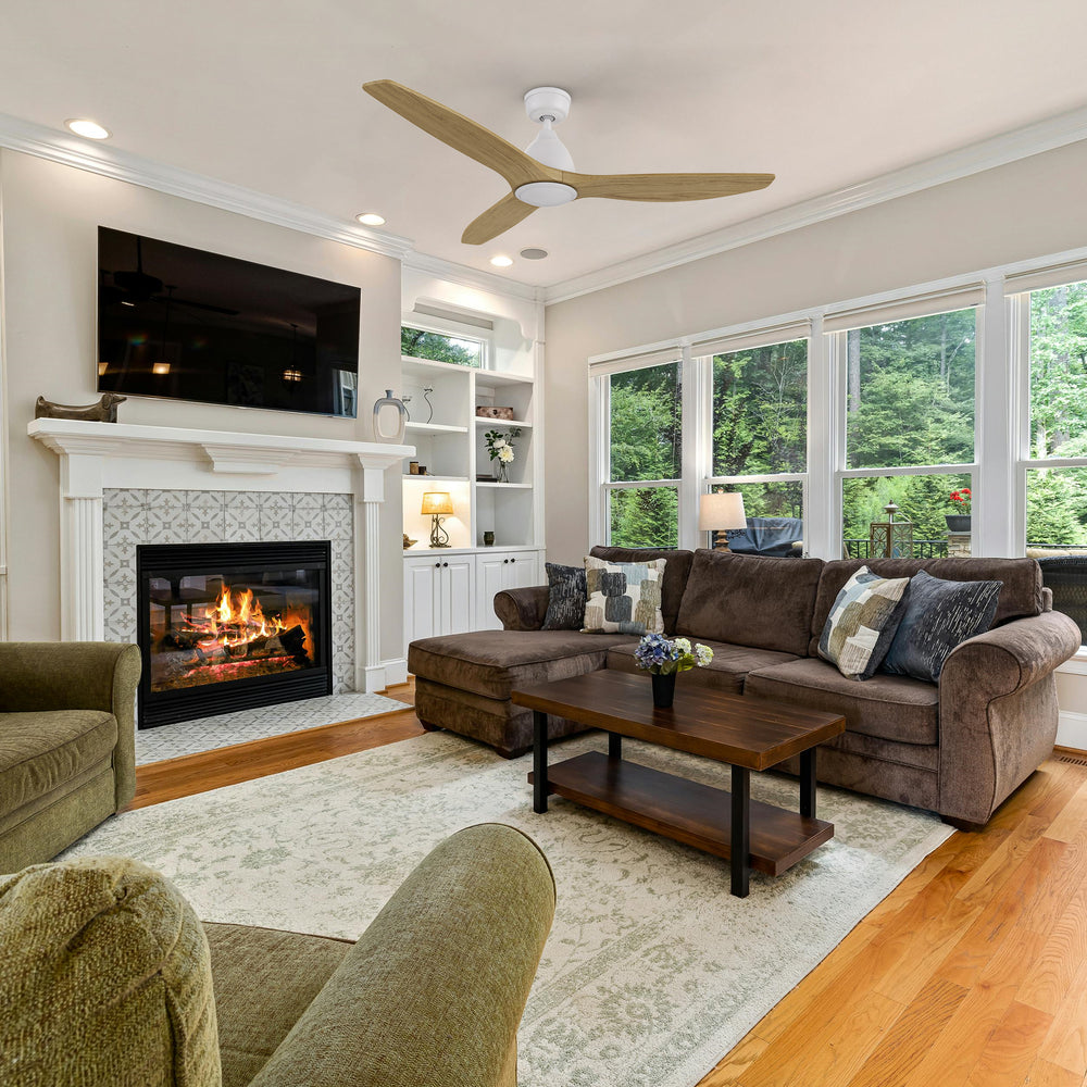 Zircon 52 inch DC motor ceiling fan without light installed in a modern living room with neutral decor, large windows, and a cozy fireplace. 