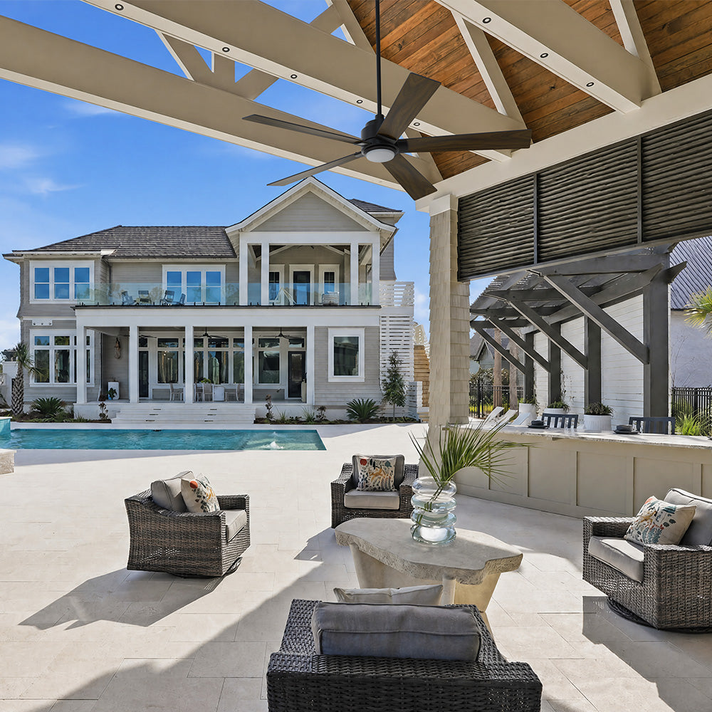 Outdoor patio featuring a 5-blade Aspen 60-inch smart ceiling fan in dark wood gra with an integrated LED light, complementing the bright, white-painted ceiling and providing a modern, functional cooling solution for the porch. 